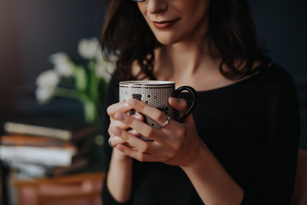 Boudoir is a form of self care which is why. you should book a boudoir photoshoot for yourself with model holding a coffee cup.