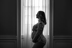 maternity boudoir best boudoir studio, in Washington D.C. featuring client standing next to window, black and white.