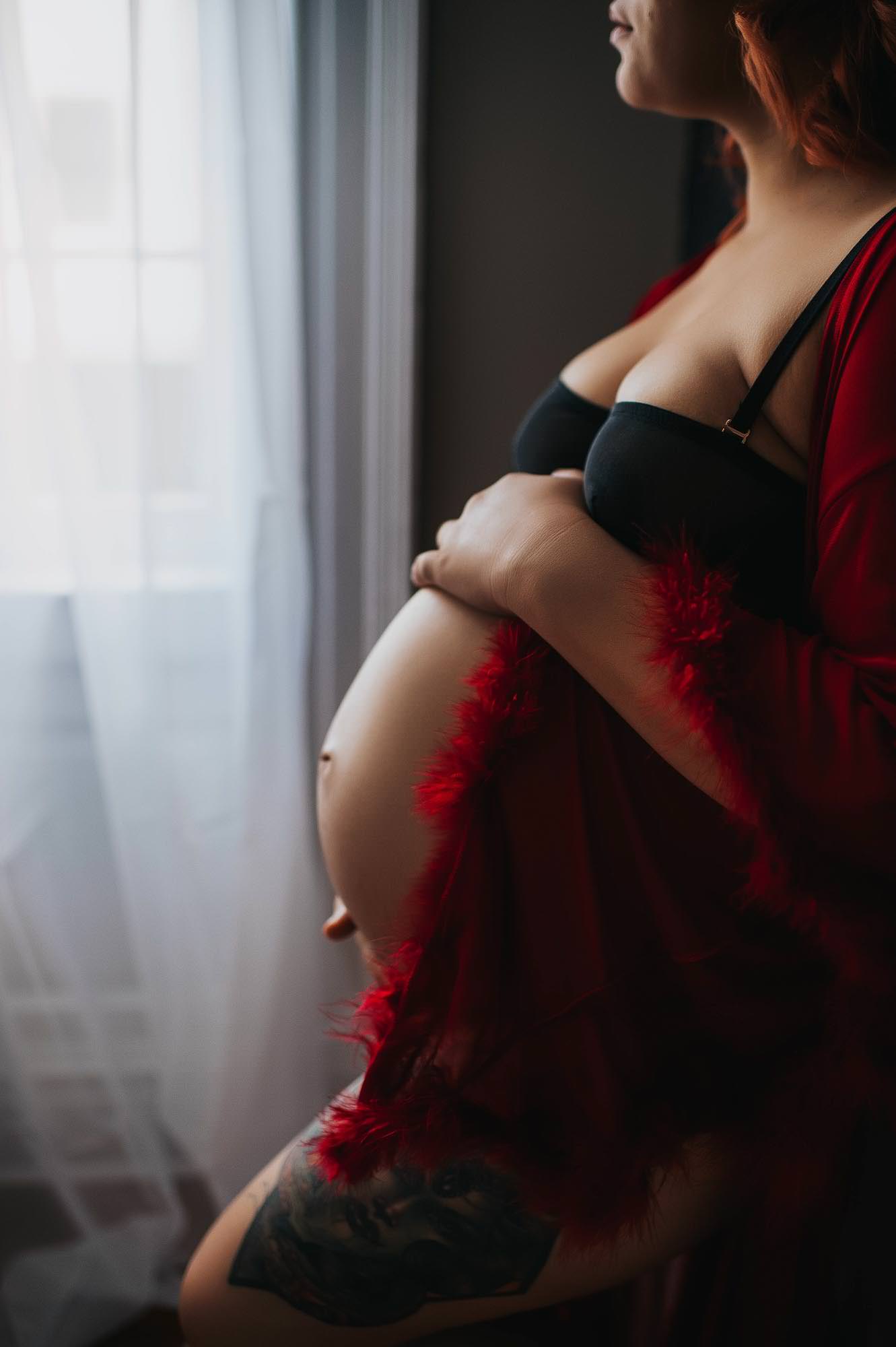 professional maternity boudoir studio, Washington D.C. and Fredericksburg Virginia featuring client posing with red robe with hands on stomach.
