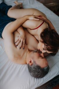 professional couples boudoir photographer in Virginia featuring clients posing in bed.