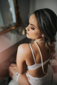 best bridal boudoir photography in Washington d.c. by Black Lace Boudoir at their luxury studio. Client sits at the vanity set.