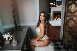 Bridal boudoir photography with model sitting at the vanity at Black Lace Boudoir's luxury studio in Virginia.