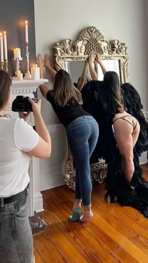 Black Lace Boudoir Photographer, Rami, teaches client how to pose for boudoir photos.